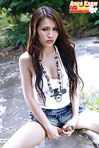 Seated on bench long hair wearing denim shorts
