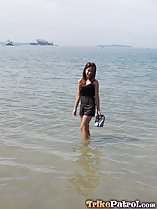 Wading in the sea holding her shoes
